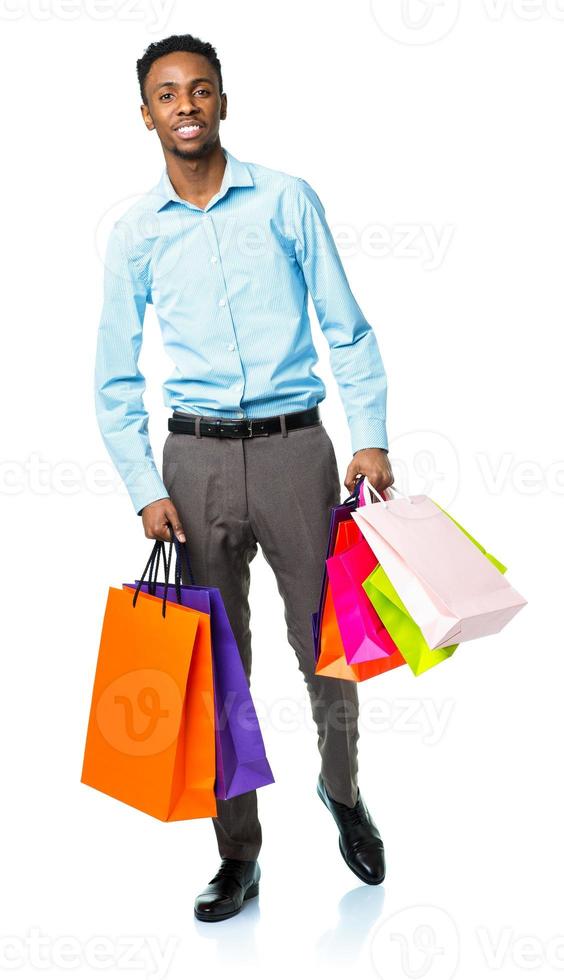 Happy african american man holding shopping bags on white background photo