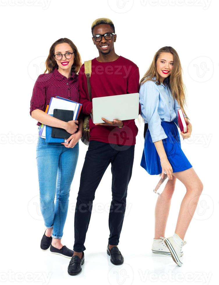 Three happy students standing and smiling with books photo