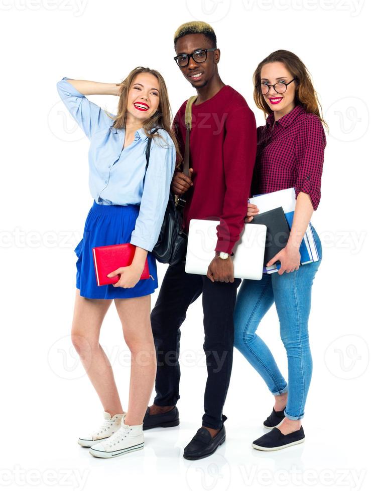Three happy students standing and smiling with books photo
