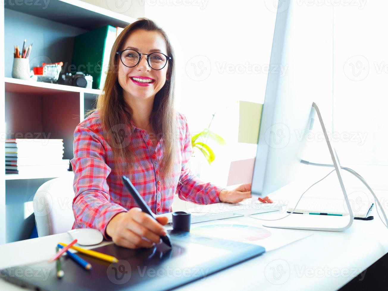 Graphic designer drawing something on graphic tablet at the work place photo