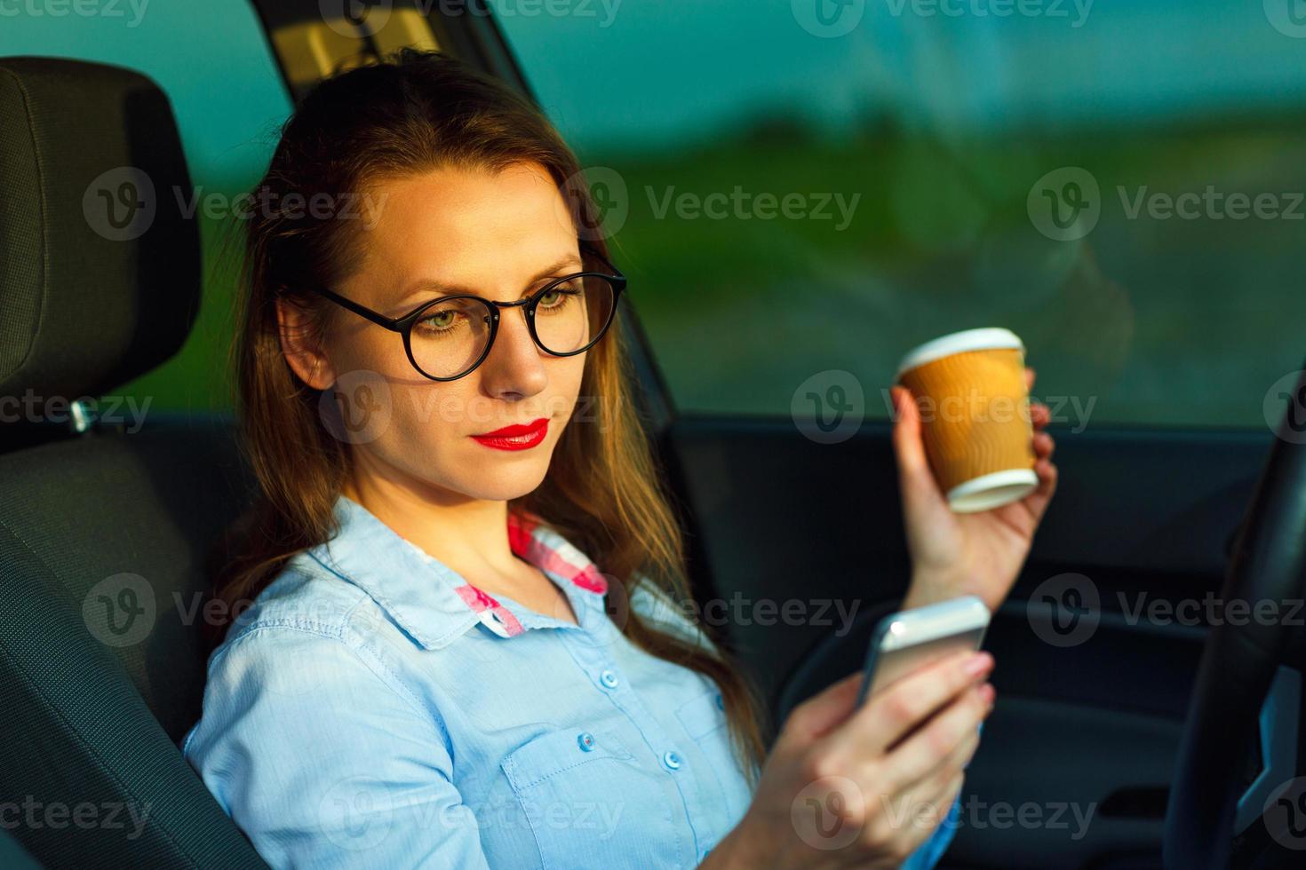 Young businesswoman sending a text message and drinking coffee while photo