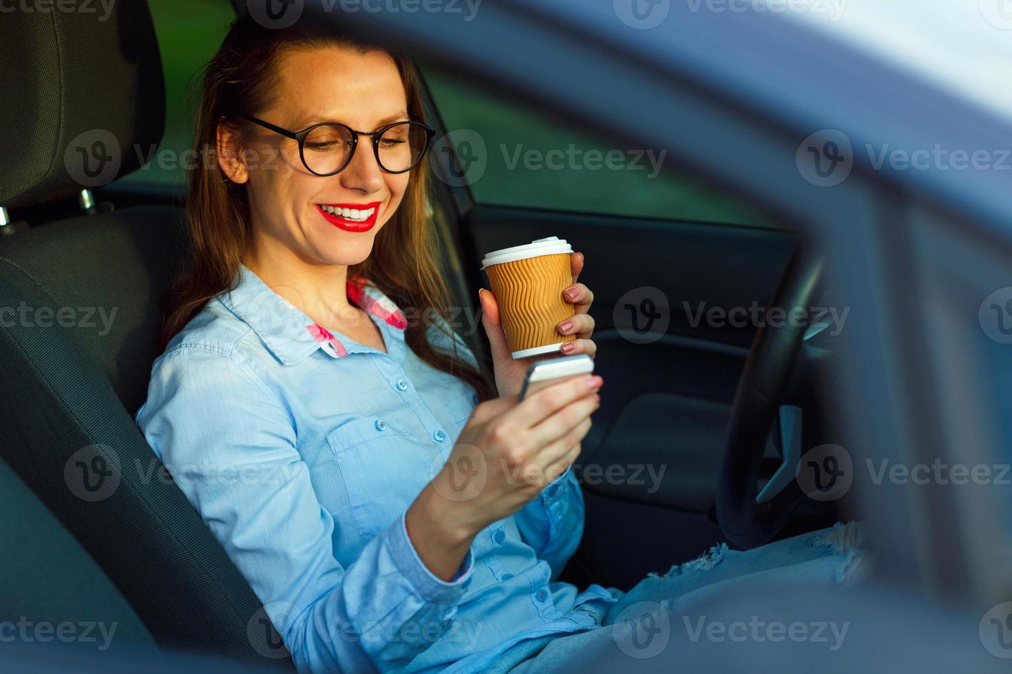 Young businesswoman sending a text message and drinking coffee while photo