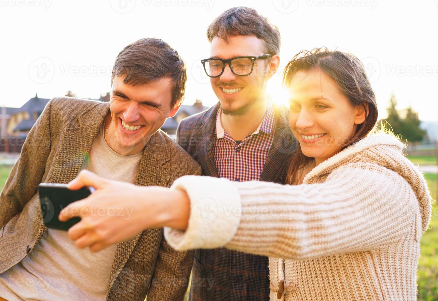 Smiling friends making selfie outdoors photo