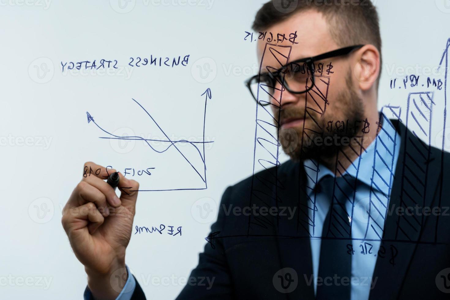 Man draws various growth charts, calculating prospects for success in a modern glass office photo