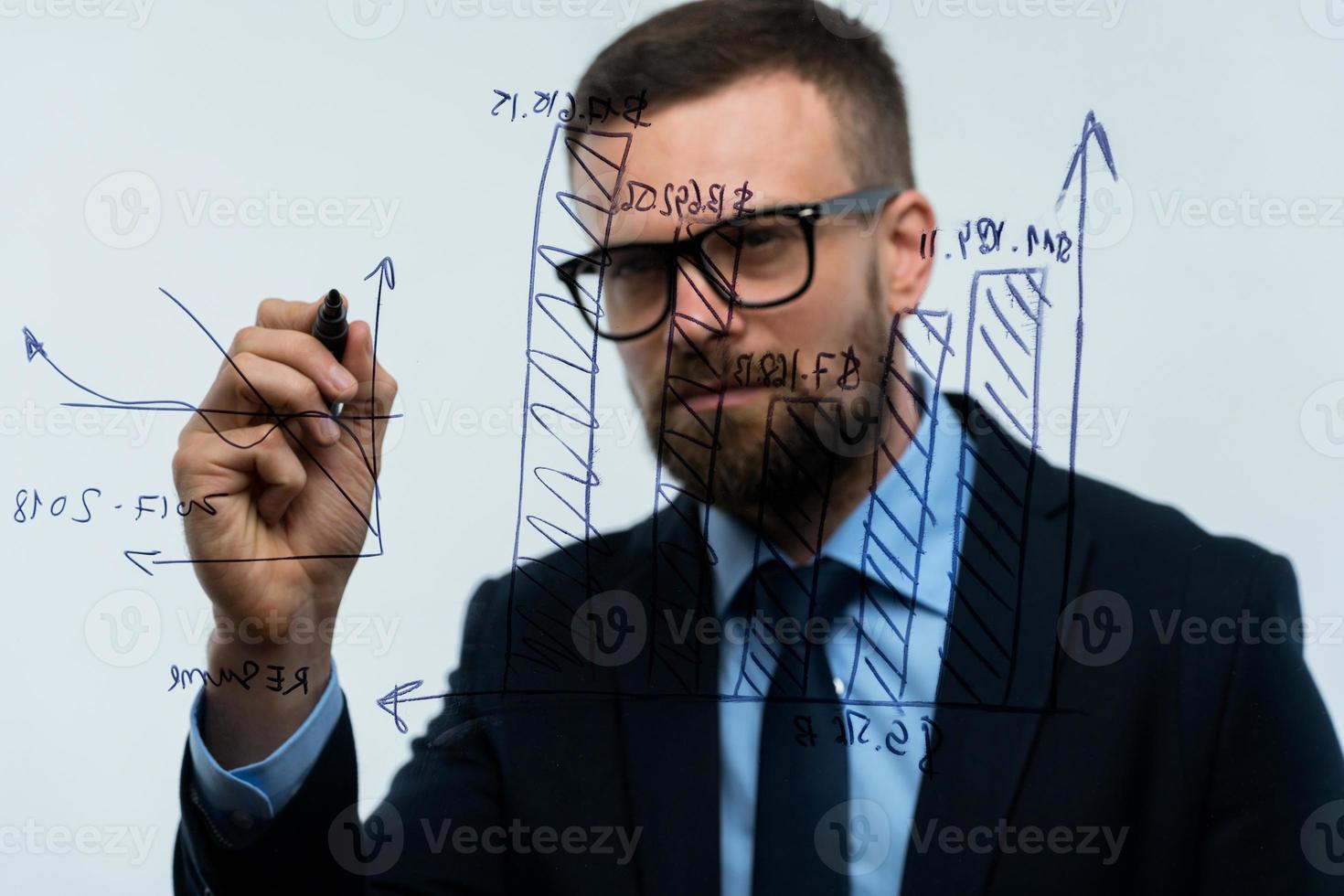 Man draws various growth charts, calculating prospects for success in a modern glass office photo