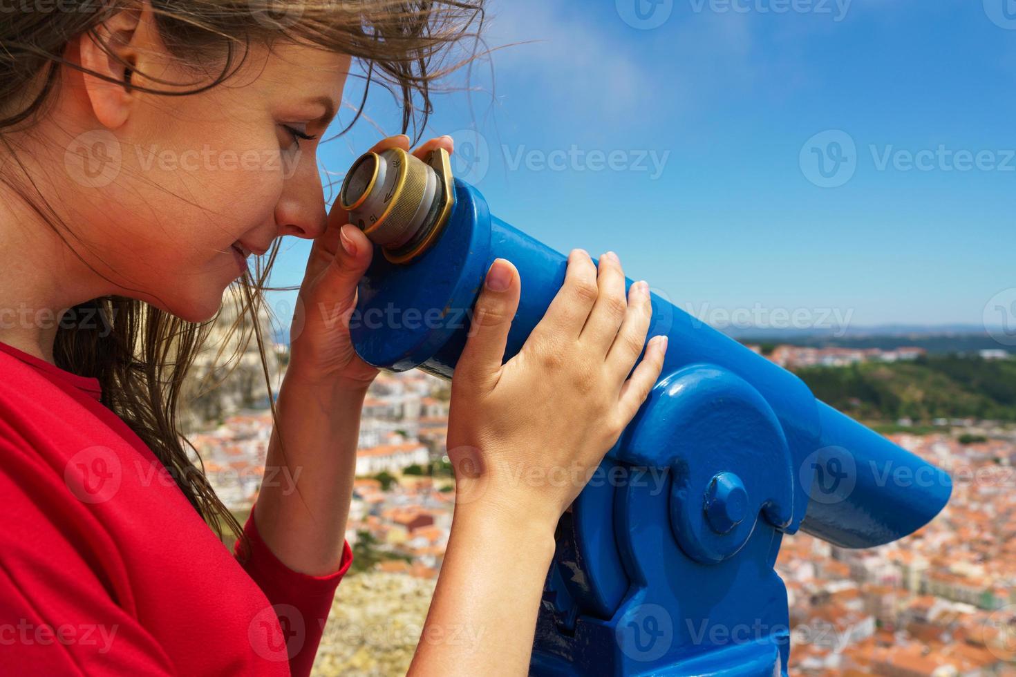 Beautiful woman using coin paid binoculars on high hill and look photo