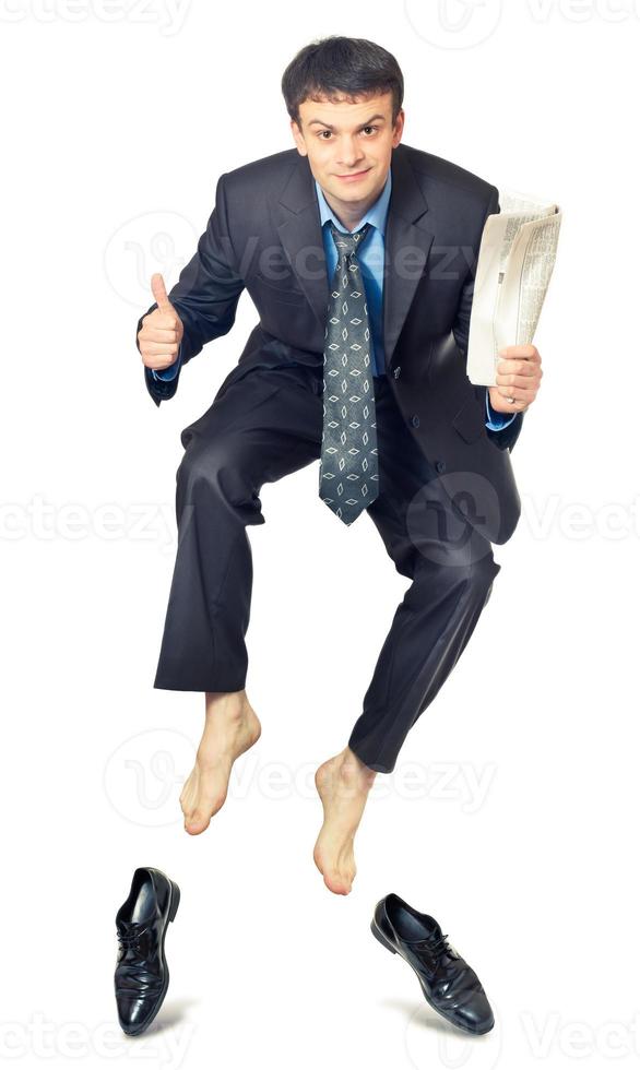 Businessman jumping with newspaper in hand photo