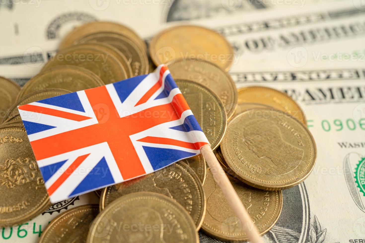 Stack of coins with United Kingdom flag and US dollar banknotes. photo