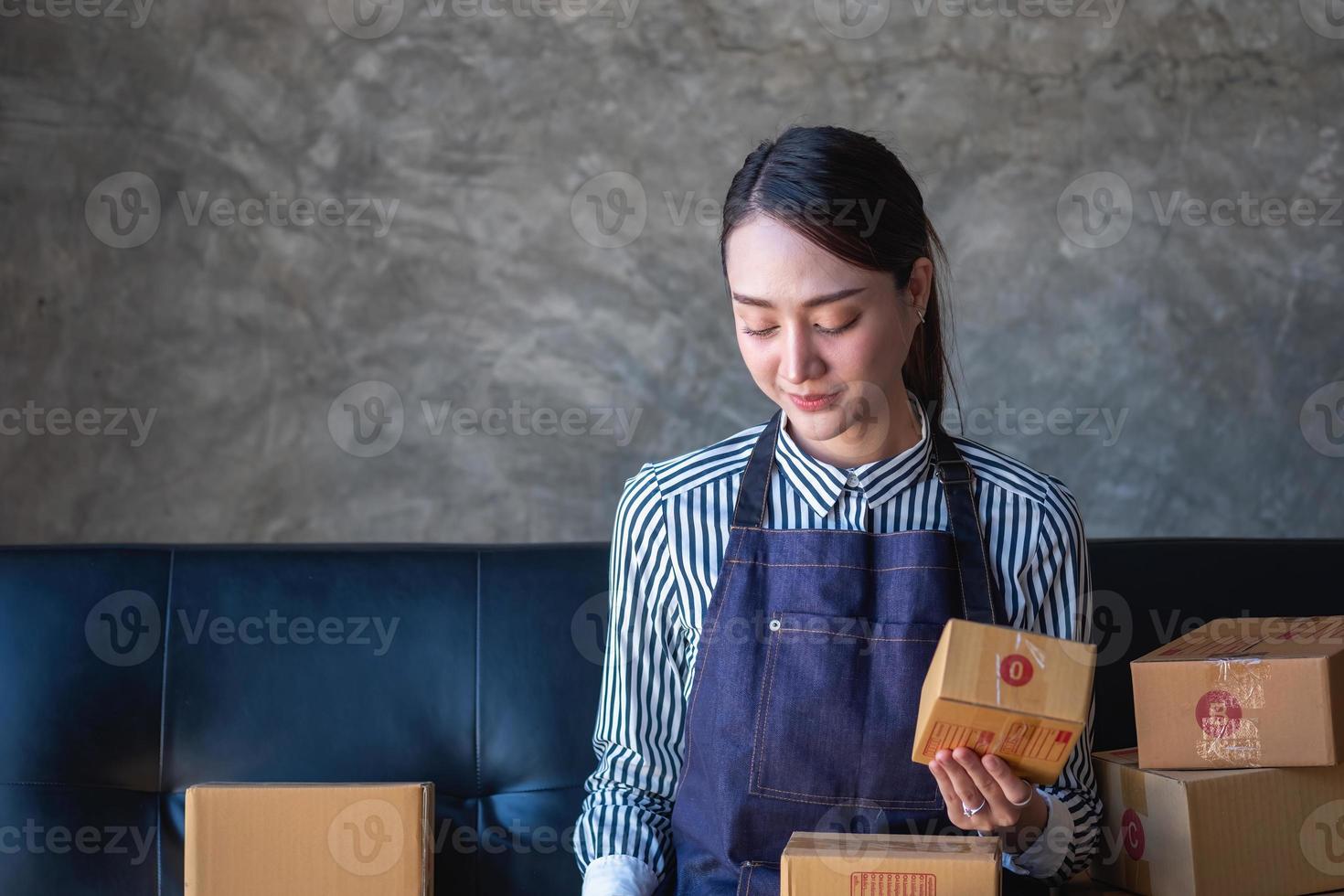 Asian female entrepreneur starting an online sales business using laptops, tablets, and smartphones to place orders and check products inside her own office, SME online concept. photo