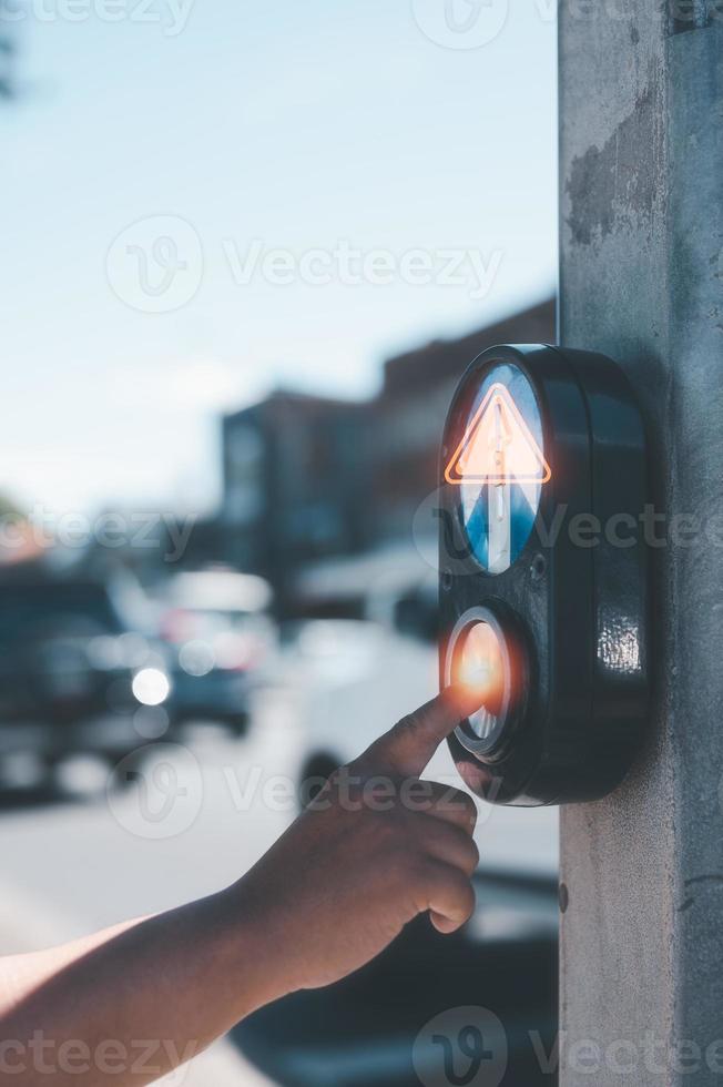 safety on the crossing street light, hand pressing pedestrian light for cross the road photo