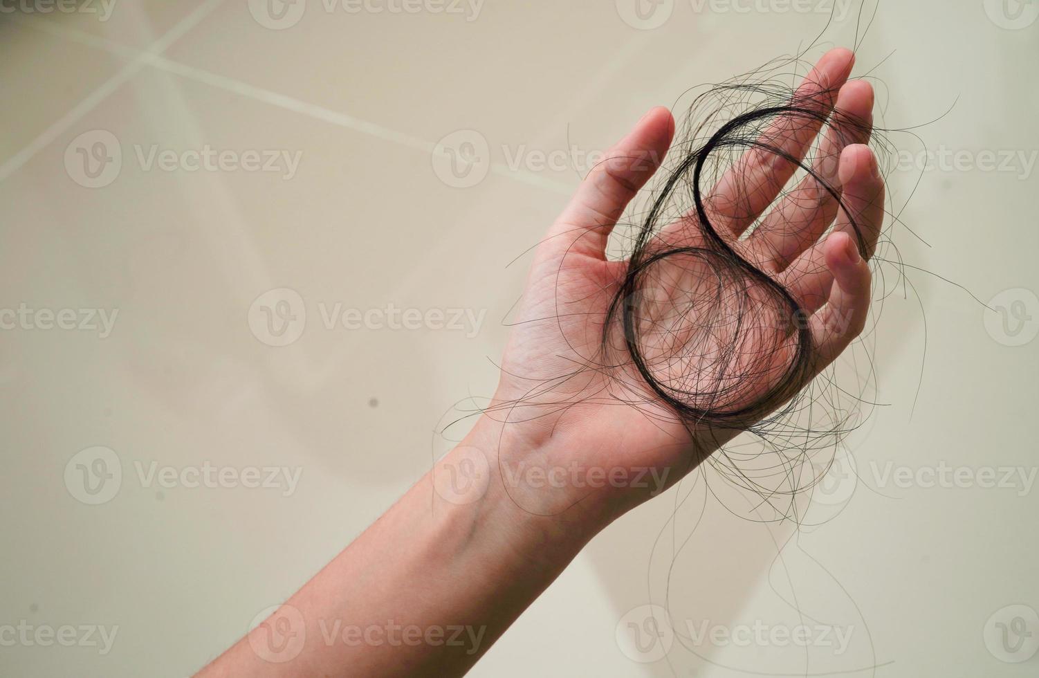 Asian woman have problem with long hair loss attach in her hand. photo