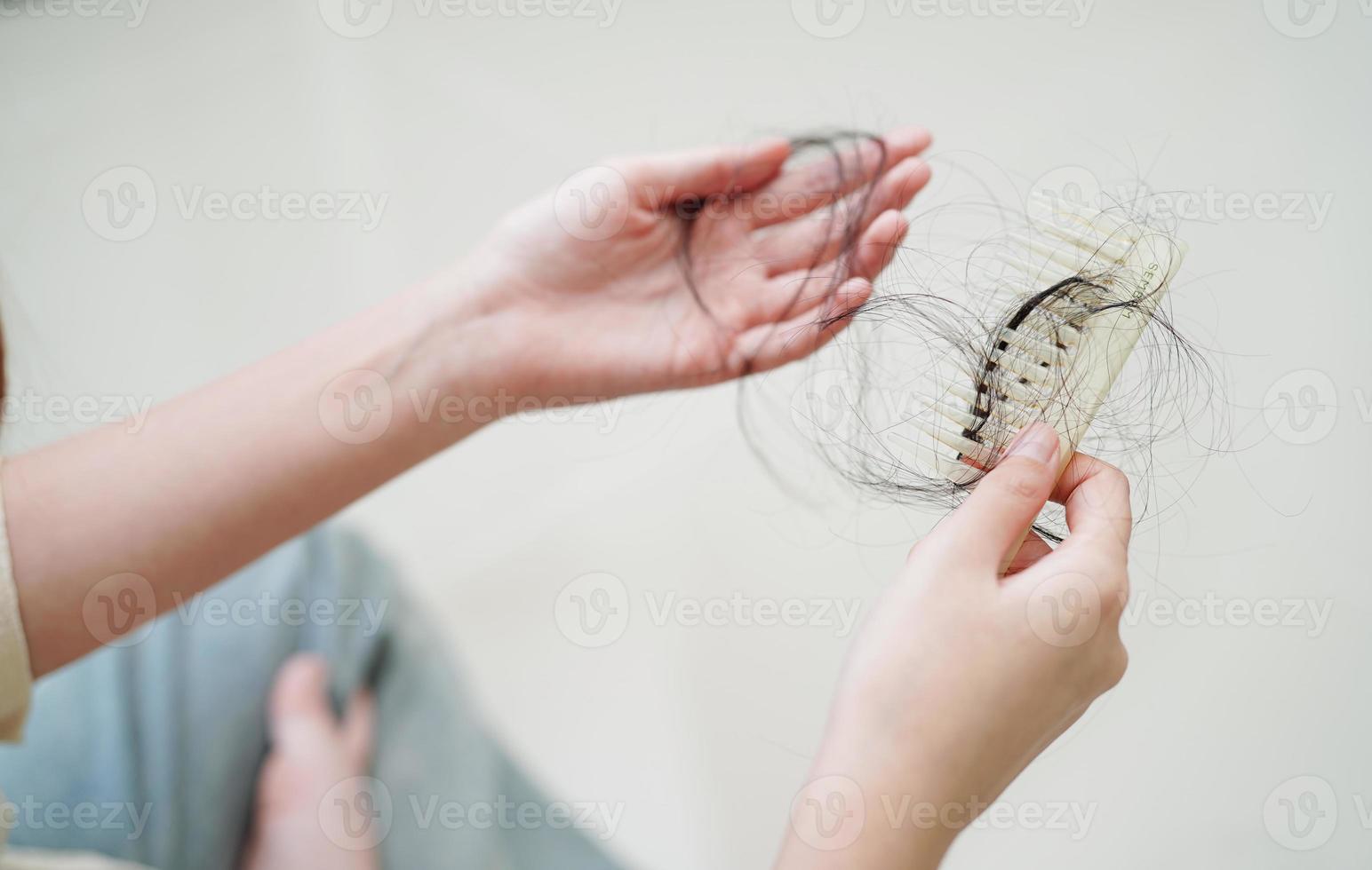 Asian woman have problem with long hair loss attach in her hand. photo