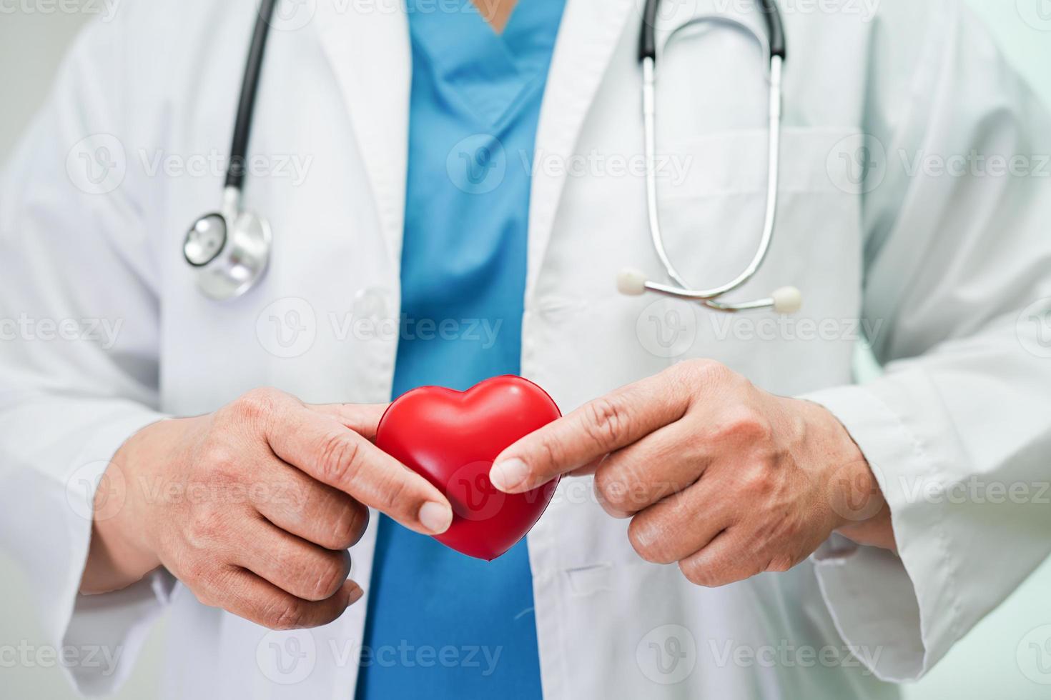 Asian woman doctor holding red heart for health in hospital. photo