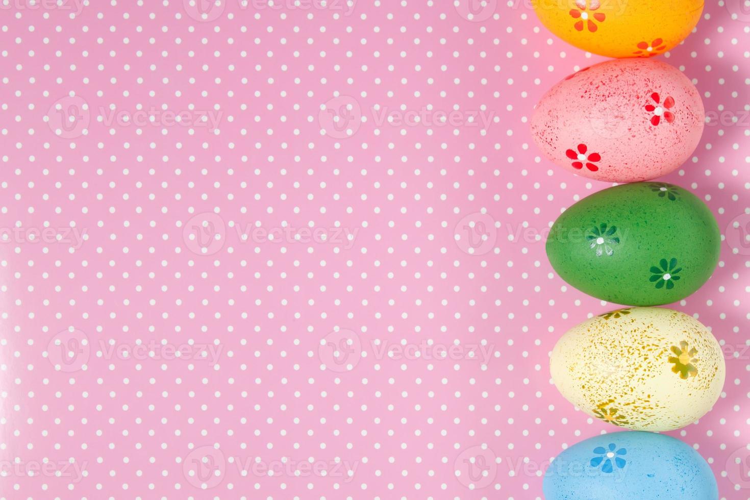 Colorful easter eggs on pink background photo