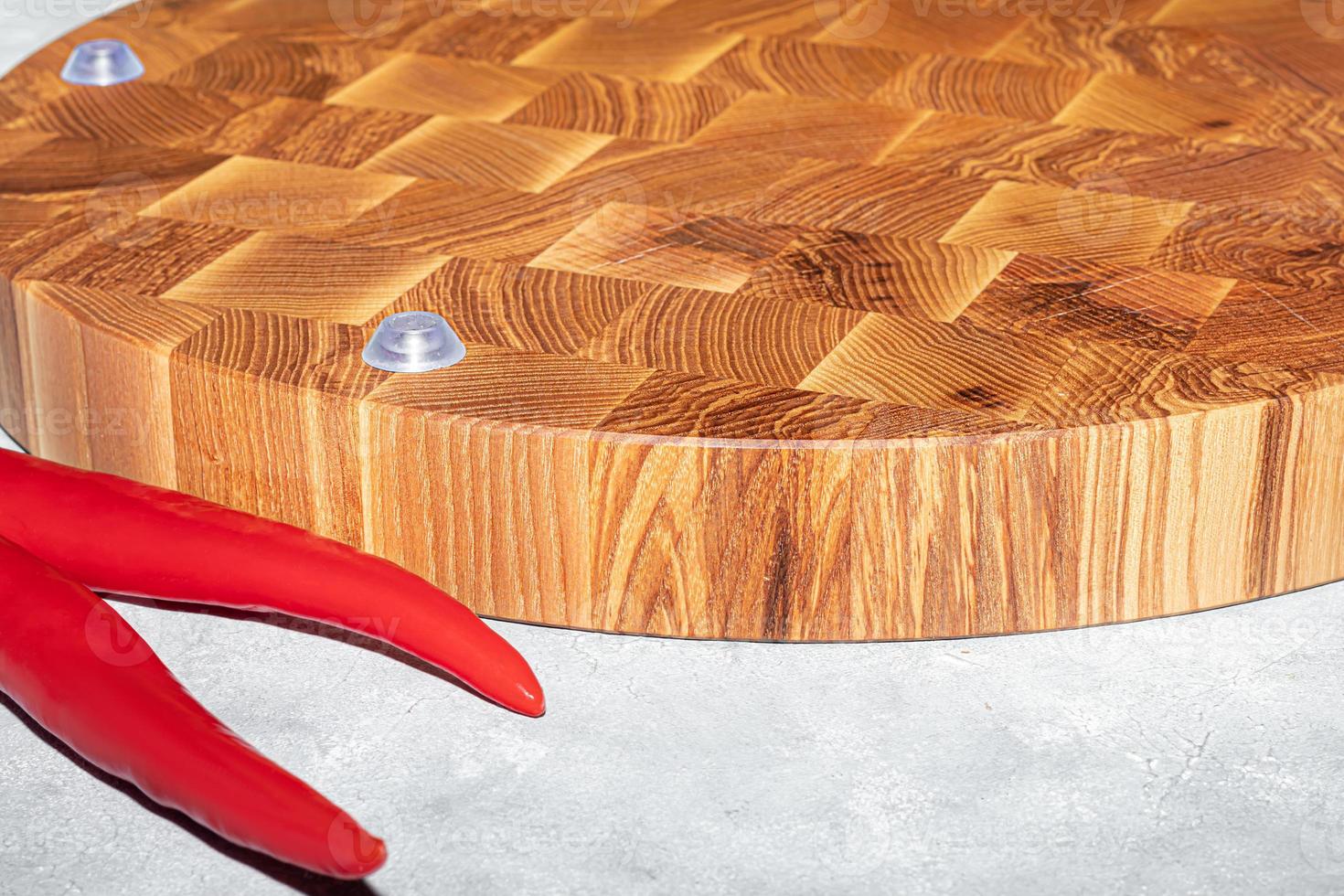 Wooden board for cutting handmade products with chopped vegetables. On a light background. photo