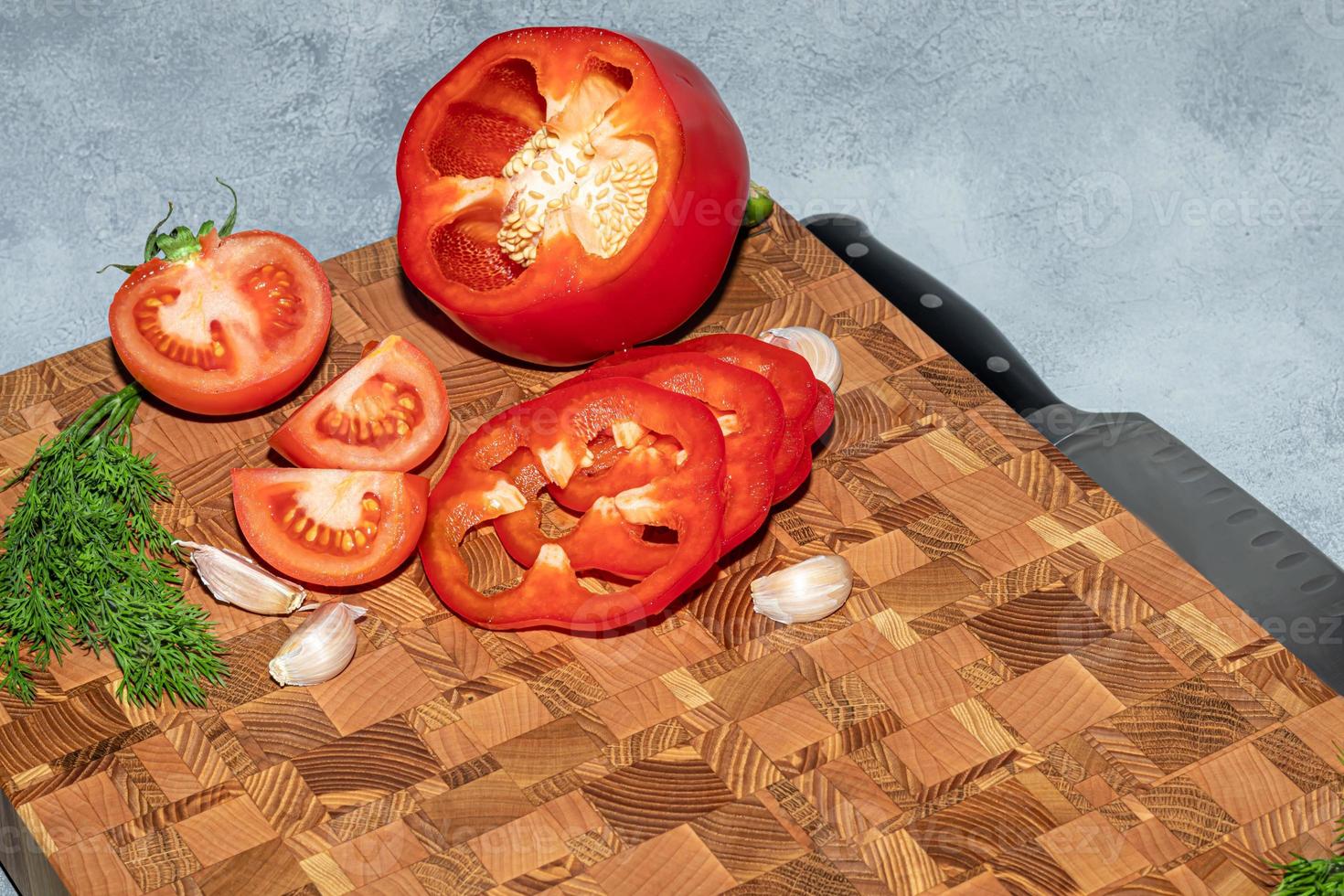 Wooden board for cutting handmade products with chopped vegetables. On a light background. photo