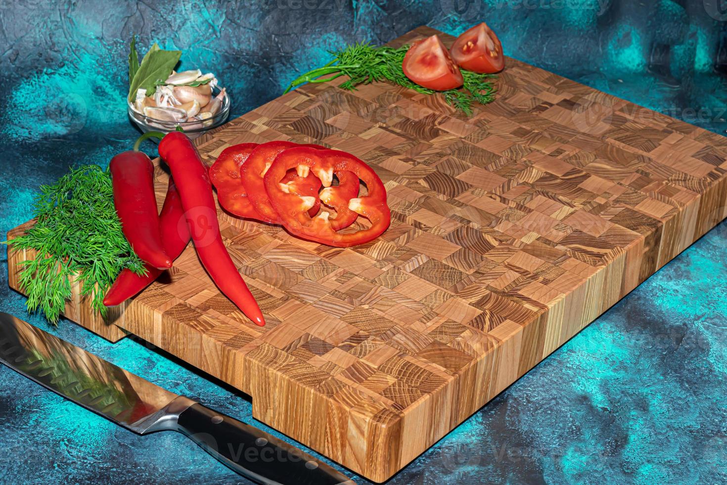 Wooden board for cutting handmade products with chopped vegetables. On a light background. photo