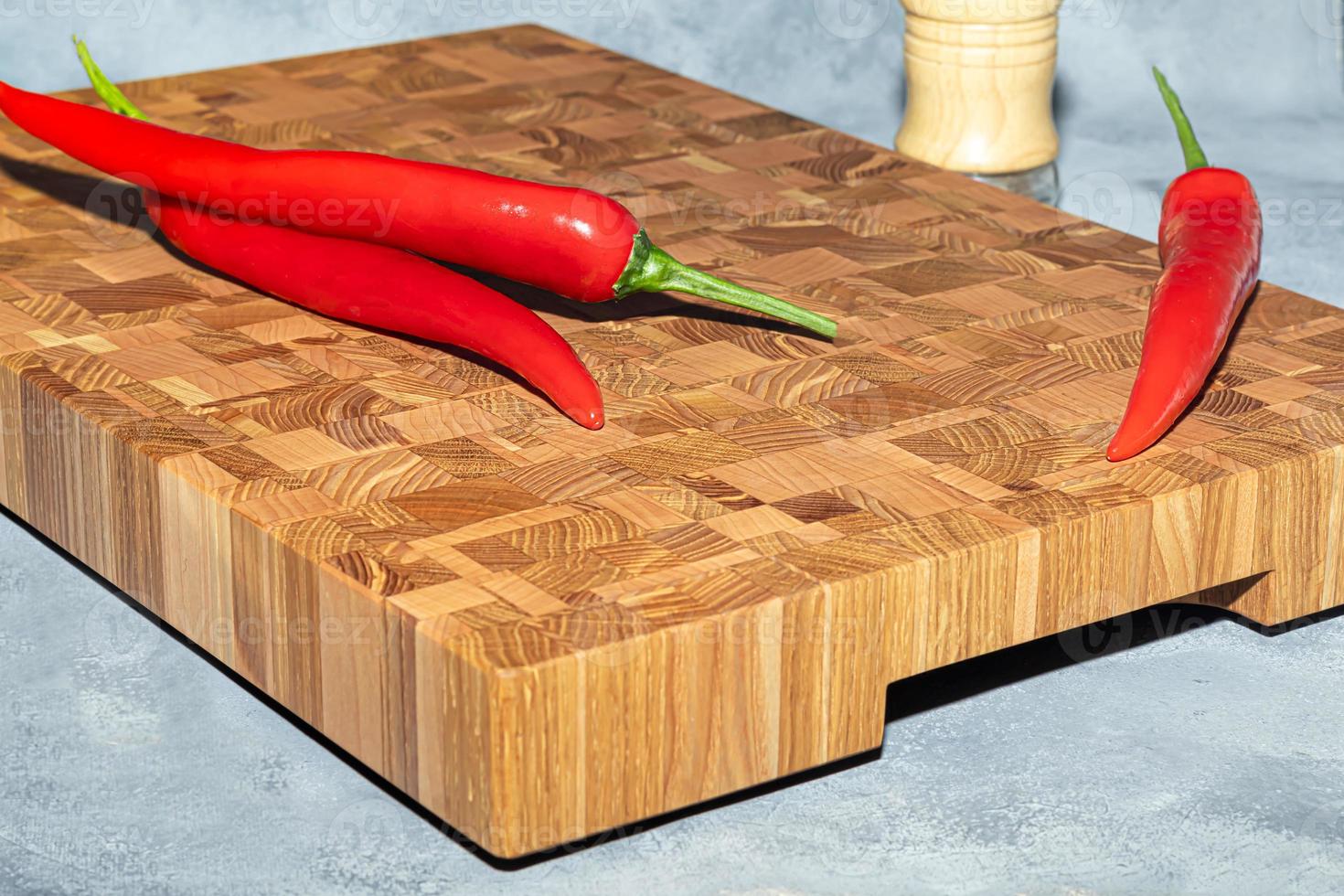 Wooden board for cutting handmade products with chopped vegetables. On a light background. photo