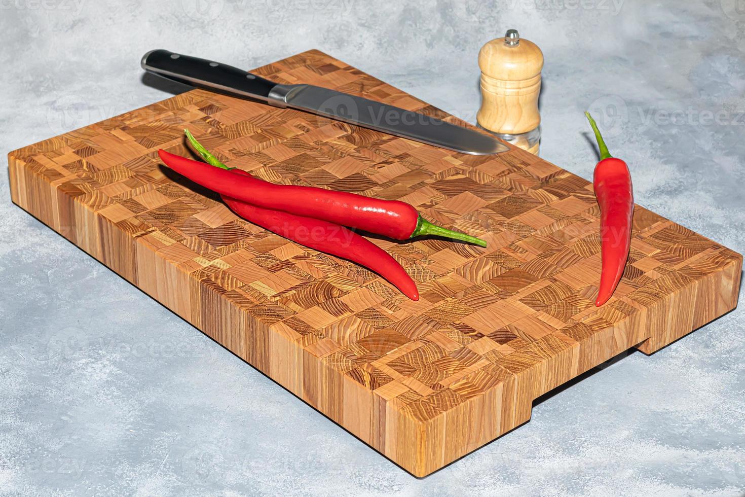 Wooden board for cutting handmade products with chopped vegetables. On a light background. photo