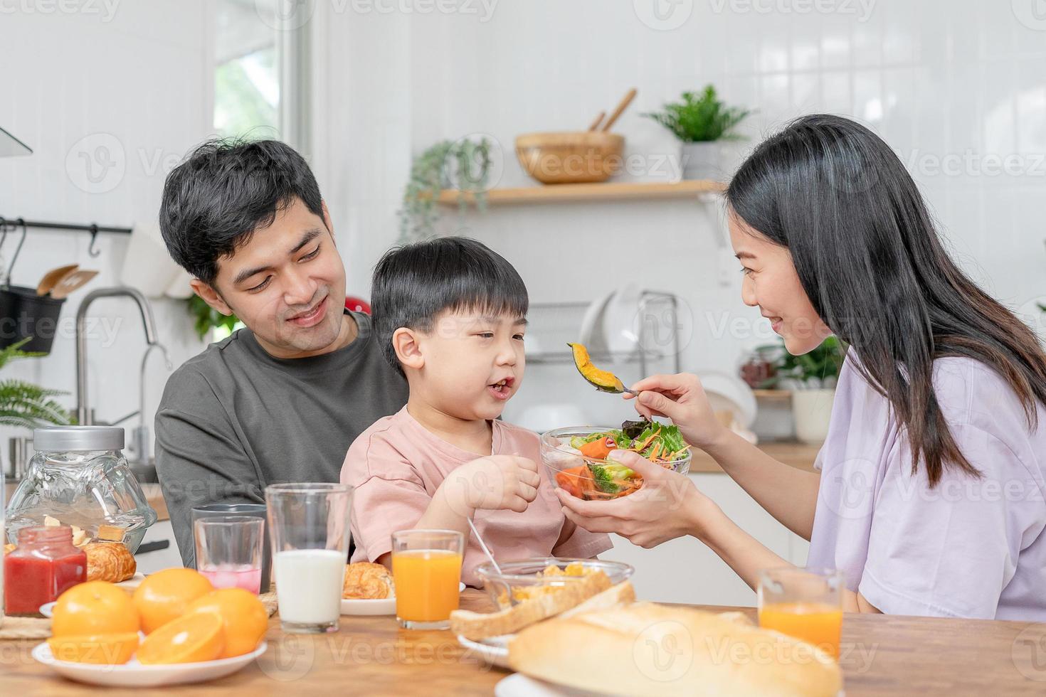 ocupaciones juntos durante el vacaciones. padres y niños son teniendo un comida juntos durante el vacaciones. madre preparar Leche para hijo en mañana, disfrutar, fin de semana, vacante, familia tiempo, contento. foto