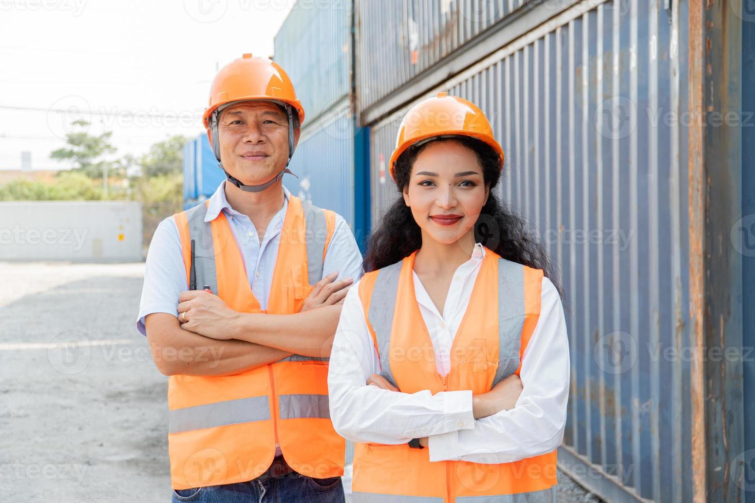 Female Asian engineer and foreman engineer loading containers from cargo ship for export. There is a container in the background. photo