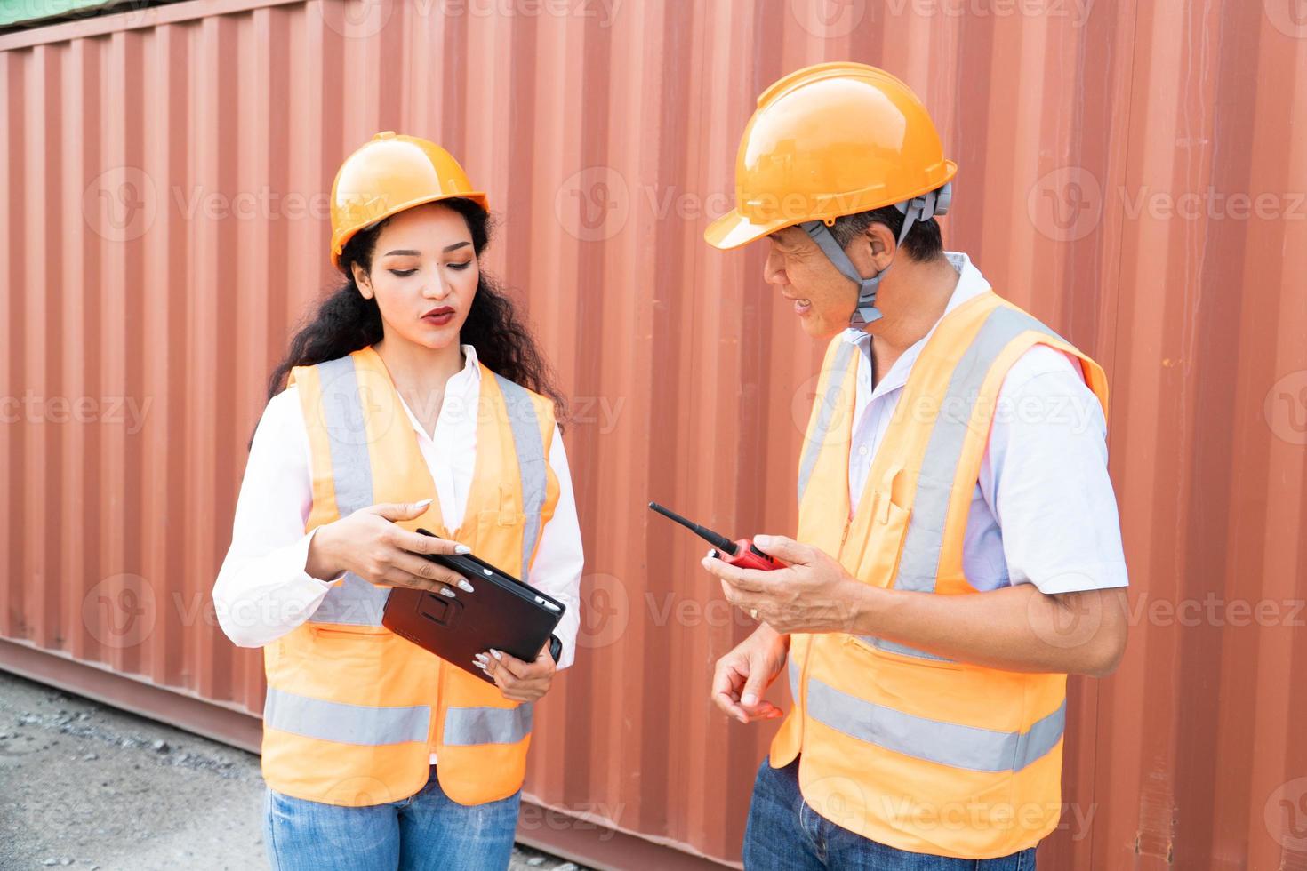 Female Asian engineer and foreman engineer loading containers from cargo ship for export. There is a container in the background. photo