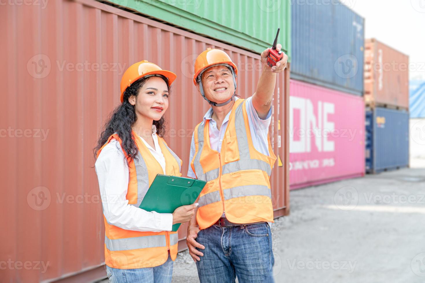 Female Asian engineer and foreman engineer loading containers from cargo ship for export. There is a container in the background. photo