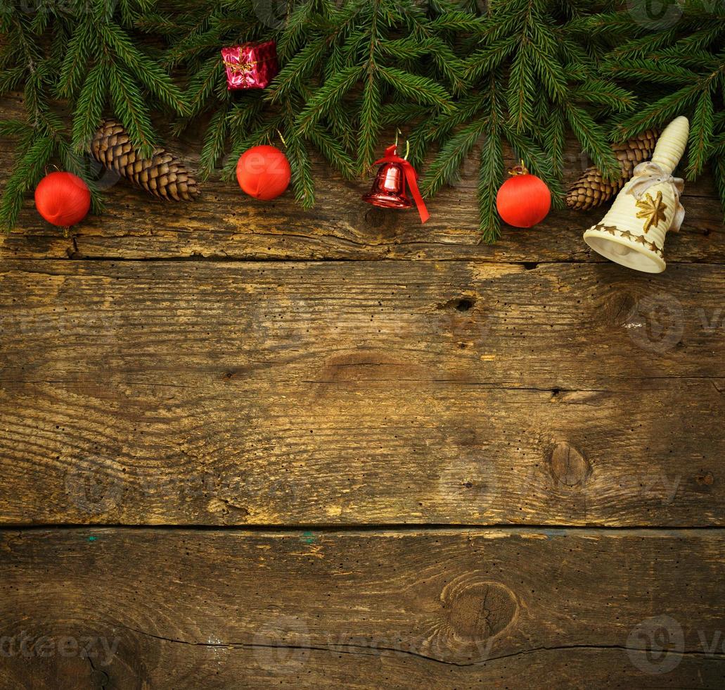 Christmas tree branches with cones and christmas decorations on wooden texture ready for your design photo