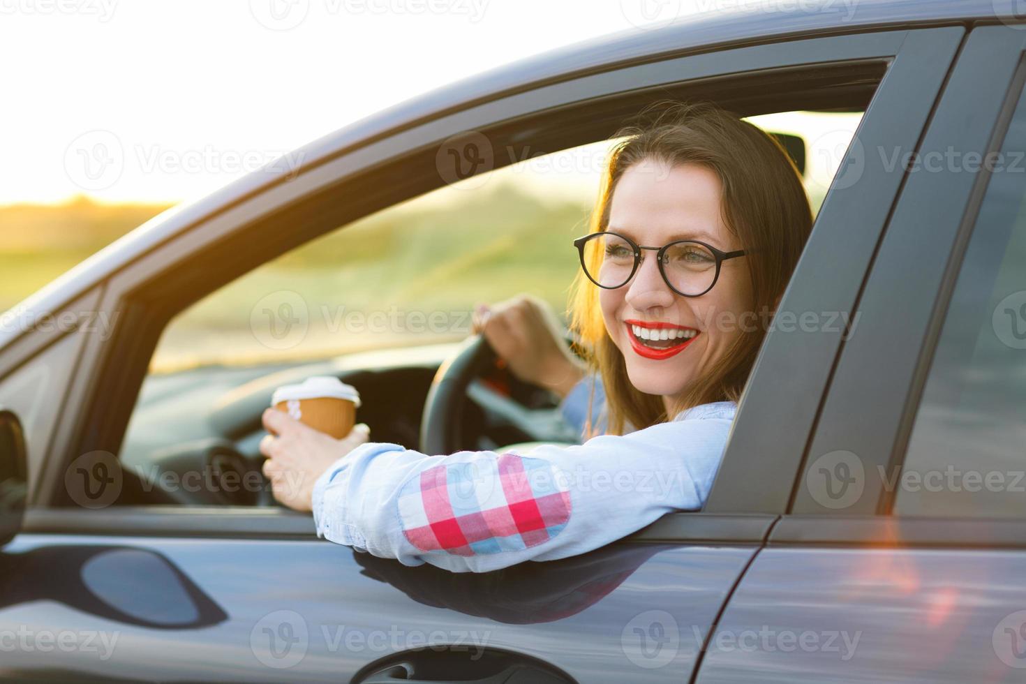 joven mujer con café a Vamos conducción su coche foto