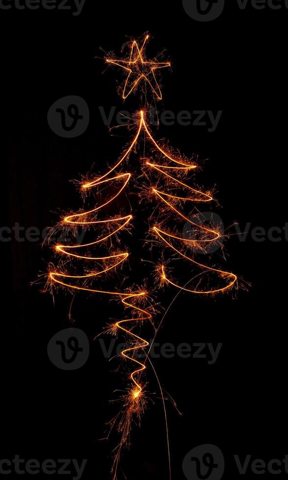 Christmas tree made by sparkler on a black photo