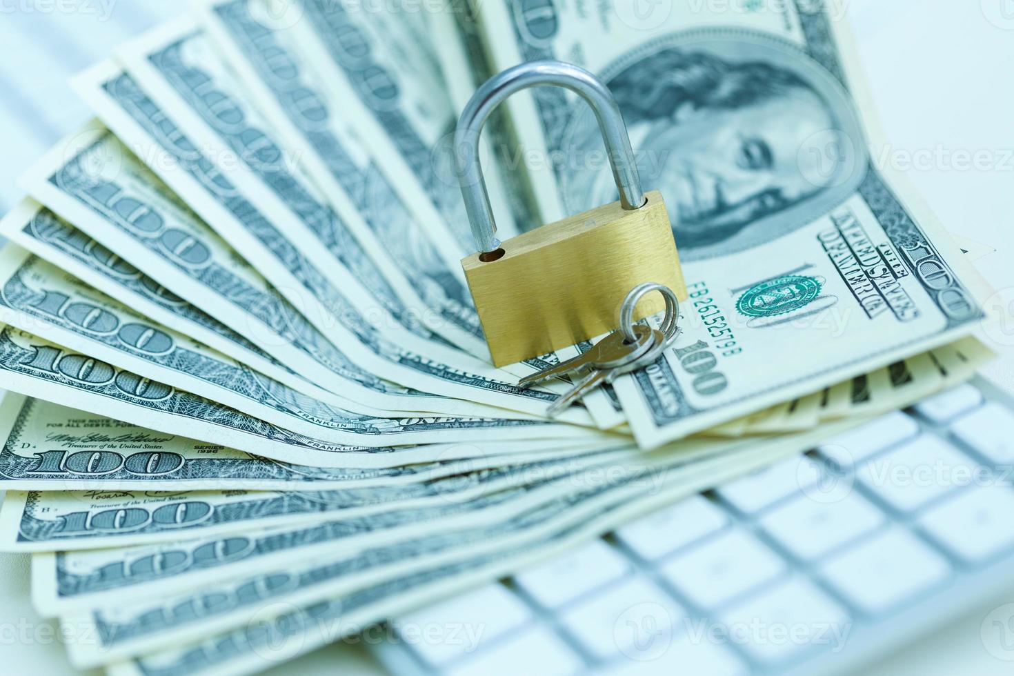 Security lock on dollar bills with white computer keyboard photo