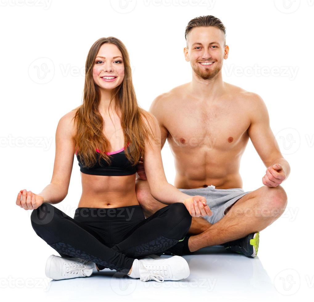 atlético Pareja - hombre y mujer practicando yoga, haciendo ejercicio para relajación foto
