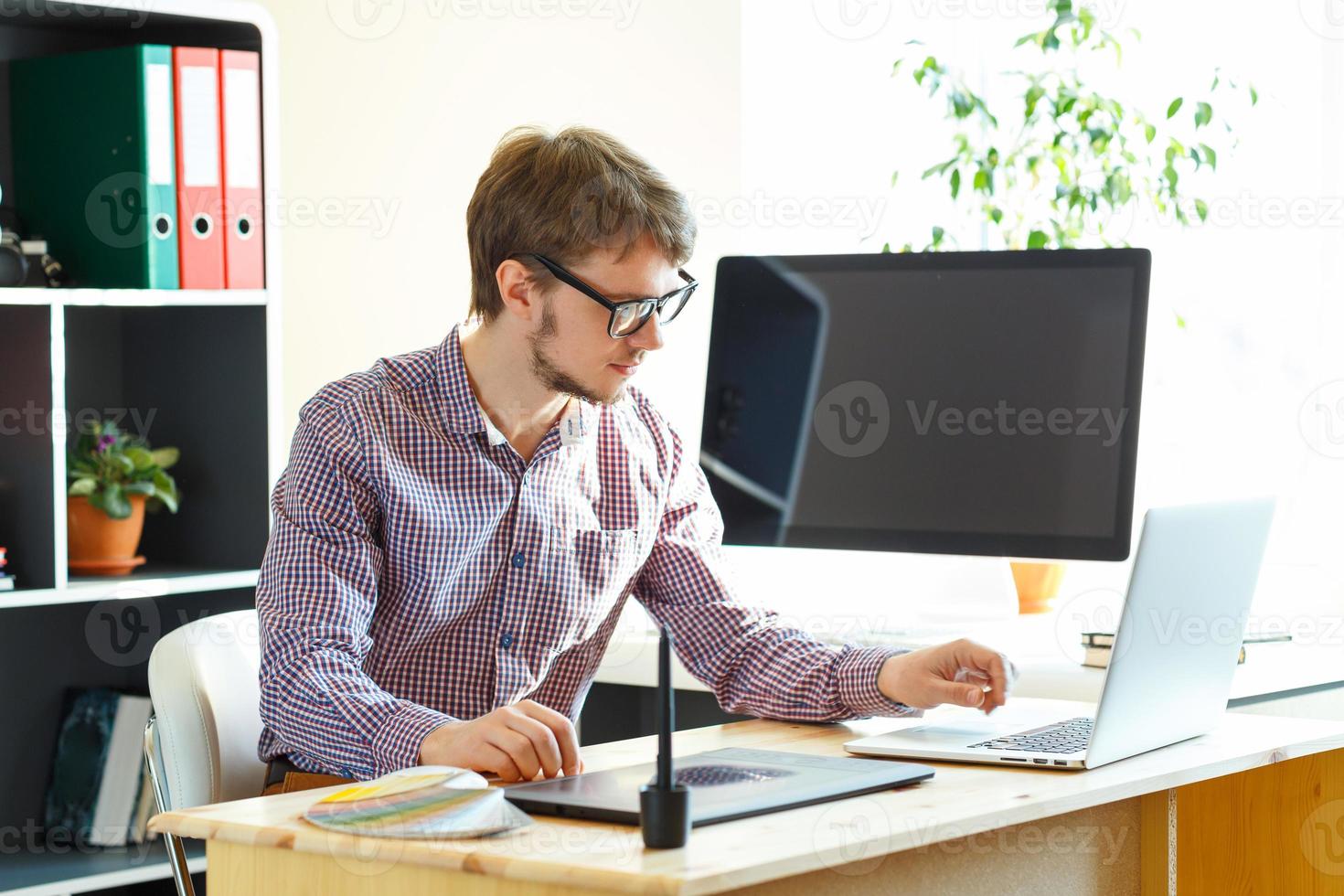 Artist drawing something on graphic tablet at the home office photo