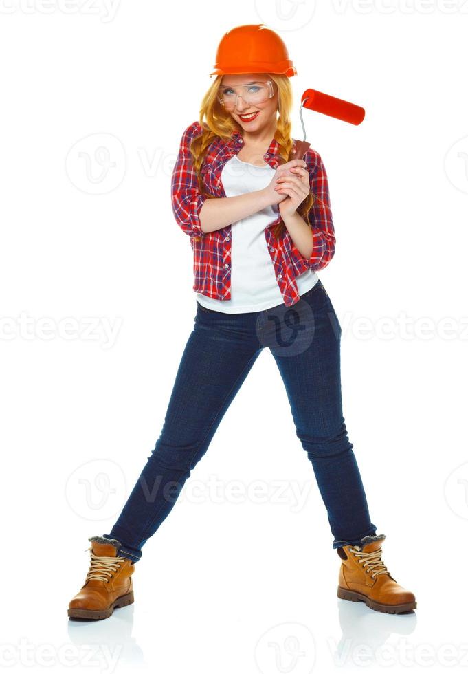 Funny girl in a helmet with roller in hand it is isolated on the white photo