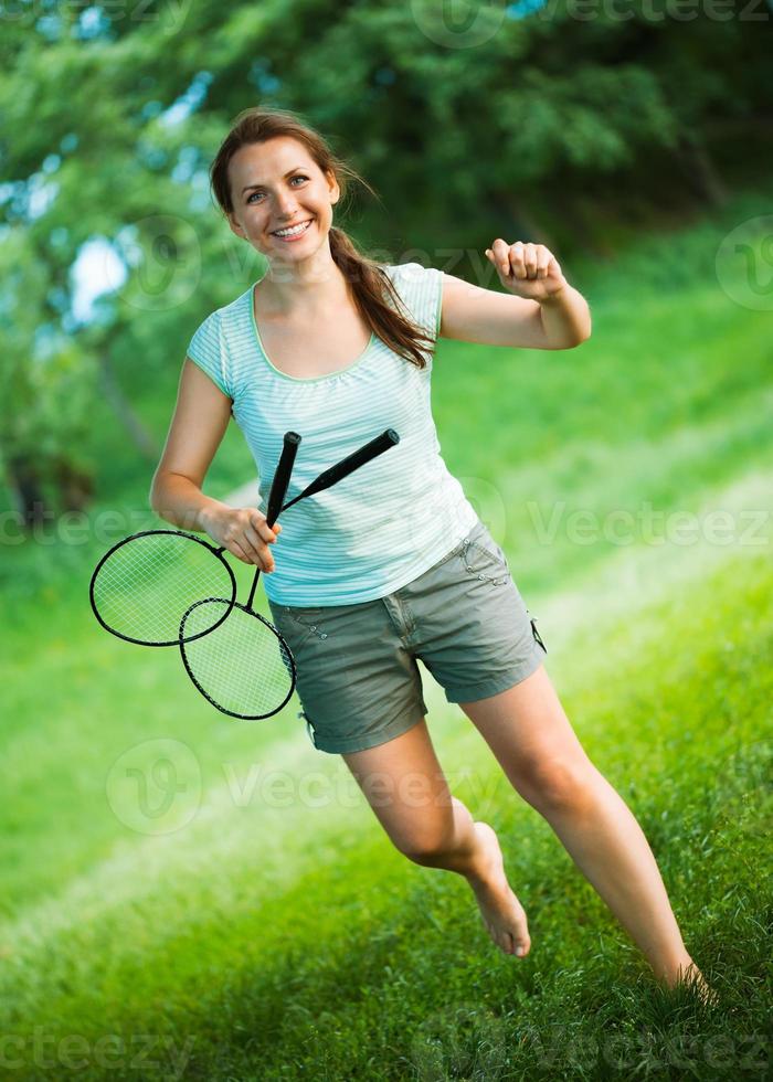 Smiling girl with a racket for a badminton in the park photo