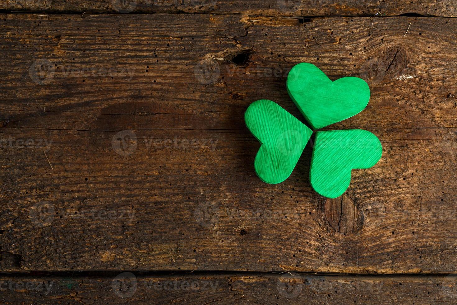 Green shamrock clovers on wooden background photo