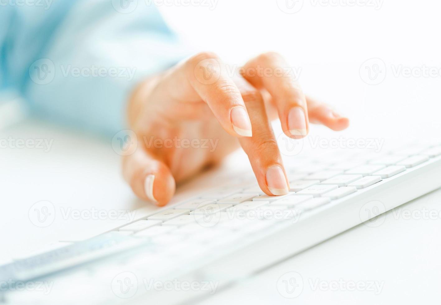 Woman office worker typing on the keyboard photo