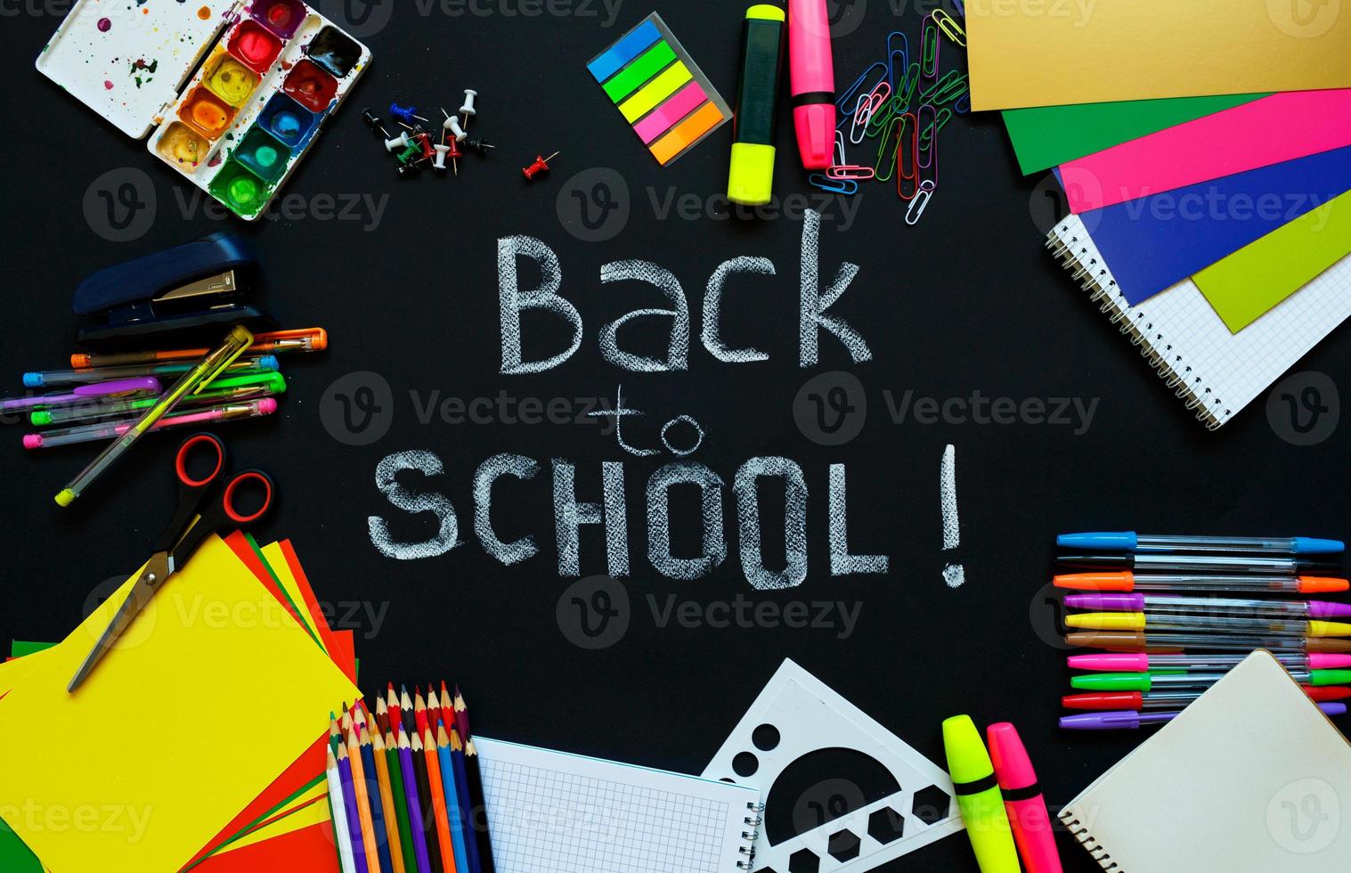 School supplies on blackboard background ready for your design photo