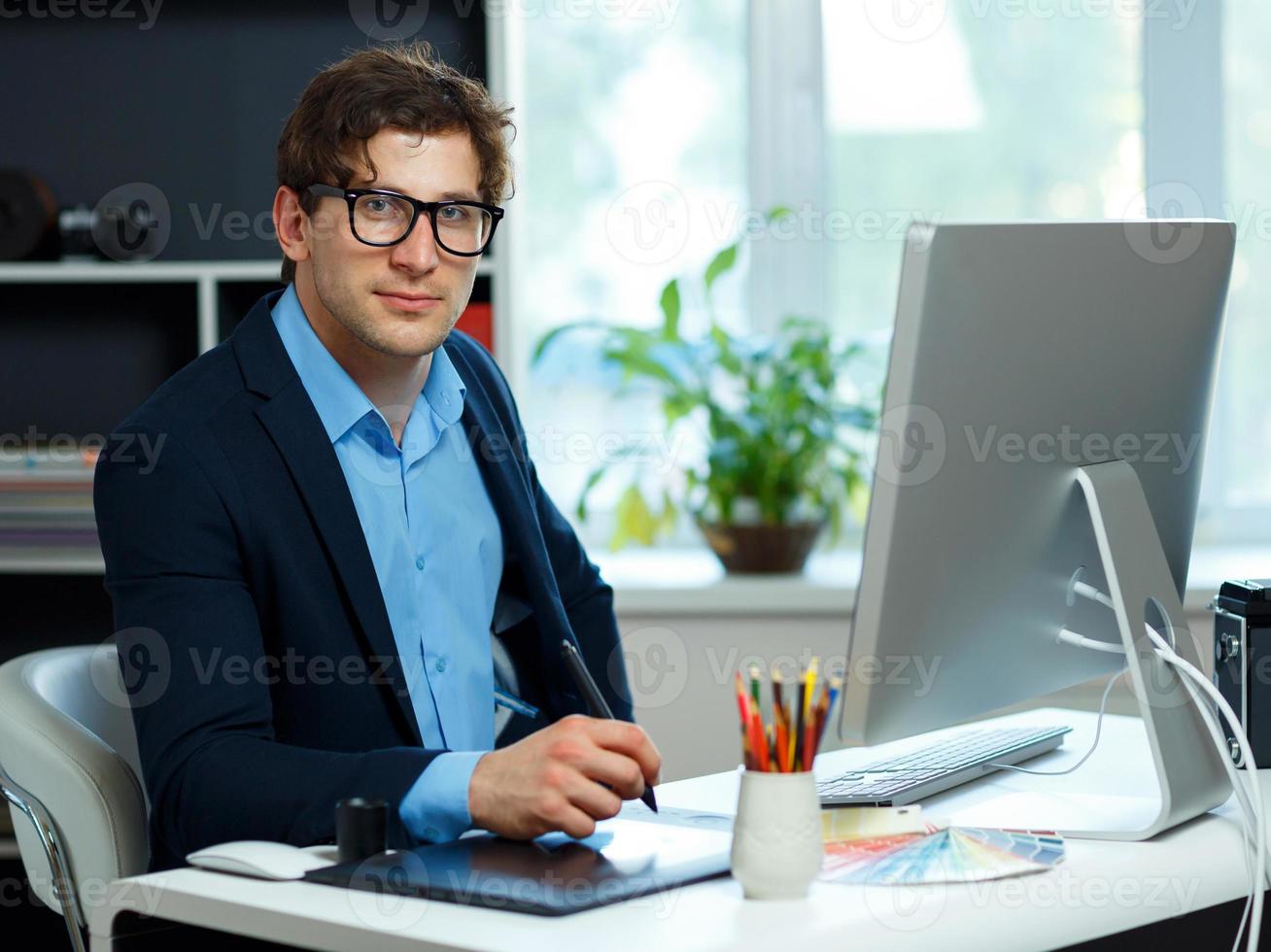 Artist drawing something on graphic tablet at the home office photo