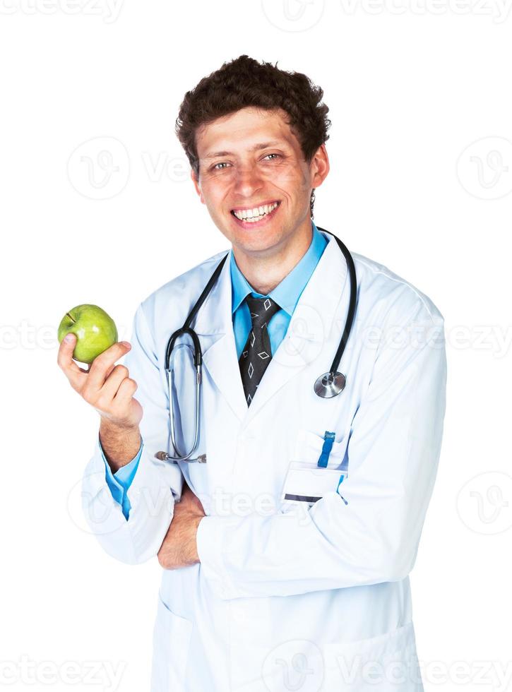 retrato de un sonriente masculino médico participación verde manzana en blanco foto