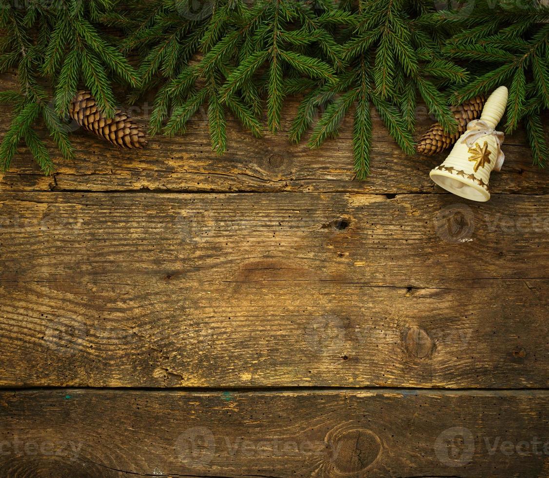 Christmas tree branches with cones and christmas decorations on wooden texture ready for your design photo