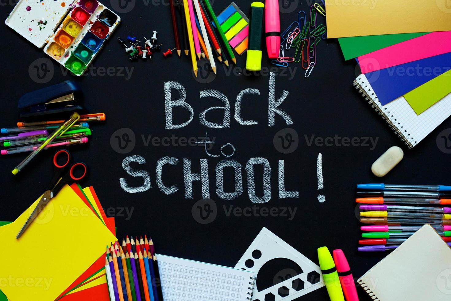 School supplies on blackboard background ready for your design photo