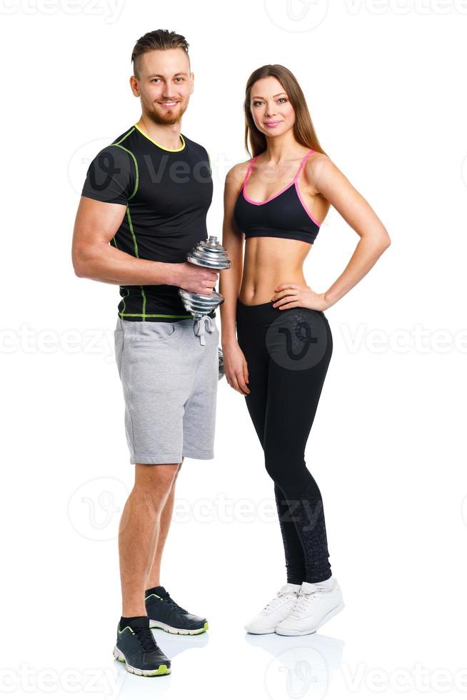 Sport couple - man and woman with dumbbells on the white photo