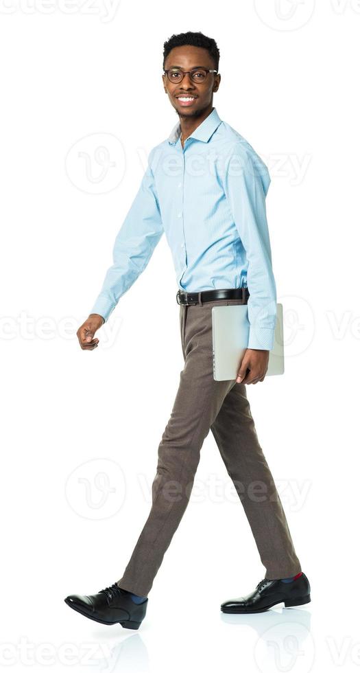 Happy african american college student with laptop standing on white photo