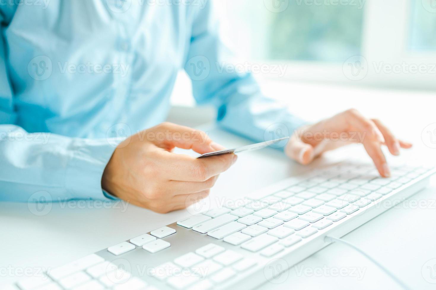 Female hands using computer and credit card on it photo