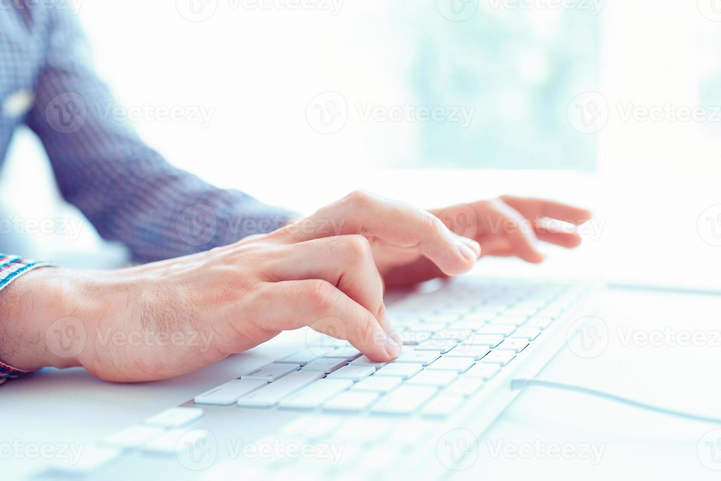 Male office worker typing on the keyboard photo