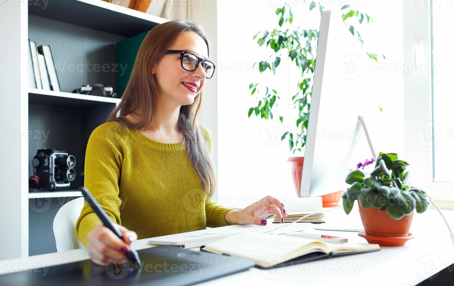 Artist drawing something on graphic tablet at the home office photo