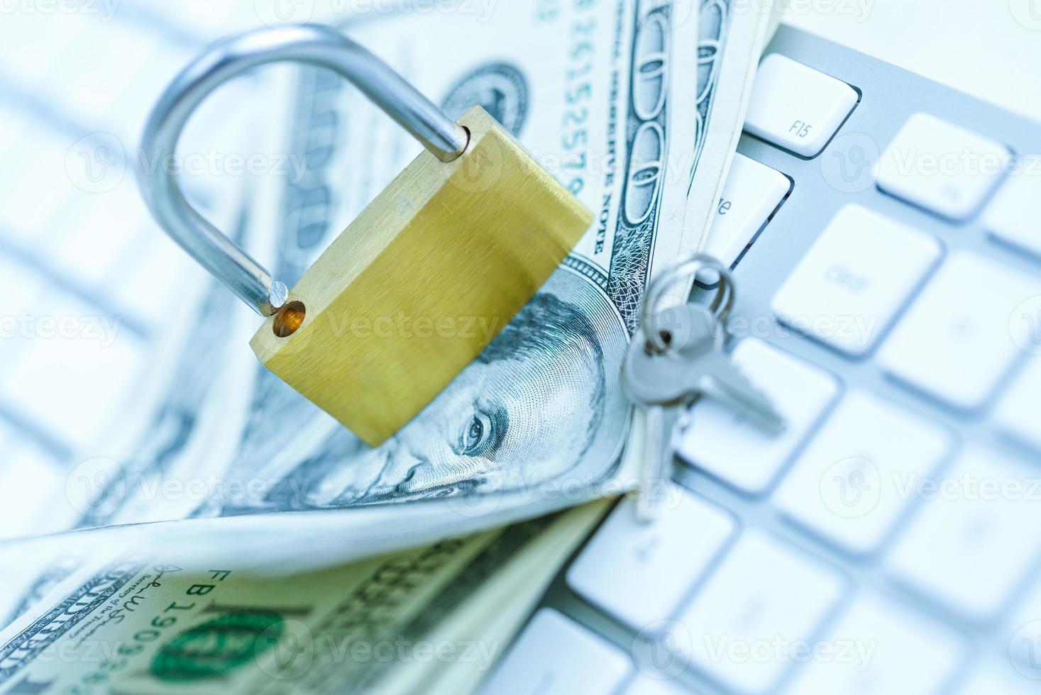 Security lock on dollar bills with white computer keyboard photo