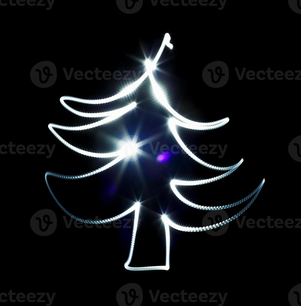 Christmas tree made with blue flashlight on a black photo