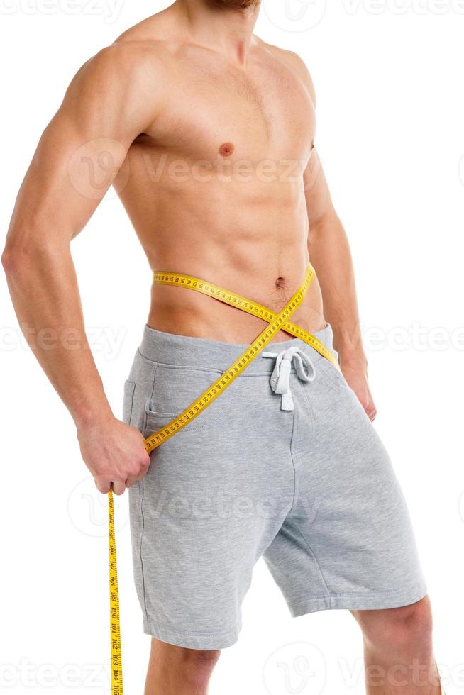 Athletic man with measuring tape on the white photo